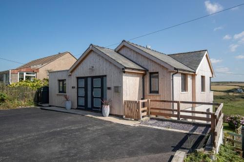 a house with a wooden fence and a driveway at Unforgettable sea views, Hot tub, Modern property in Newgale