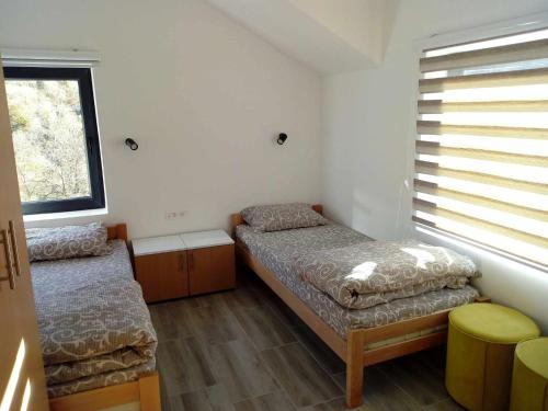 Habitación pequeña con 2 camas y ventana en STD Cvetković, en Crni Vrh