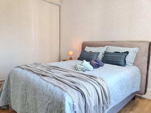 a bedroom with a large bed with blue pillows at APT 804 - Brava Beach - 3 Quartos - 2 Vagas Garagem in Cabeçudas