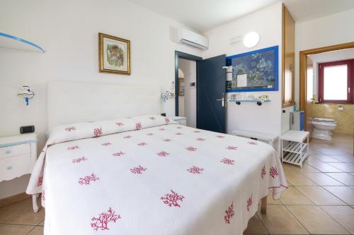 um quarto com uma cama branca com flores cor-de-rosa em L'Orso e il Mare (Adults Only) em Palau