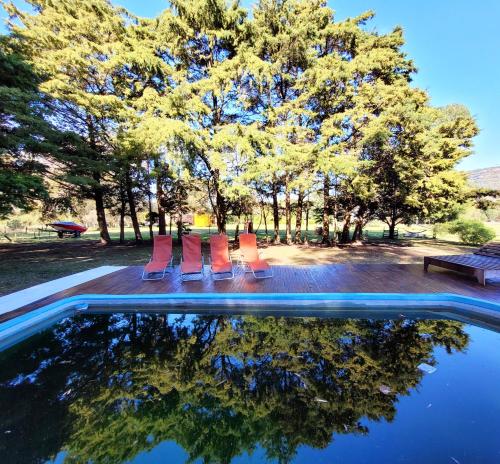 a pool with chairs and trees in a park at El Remanso in Villa Residencial Laguna Brava