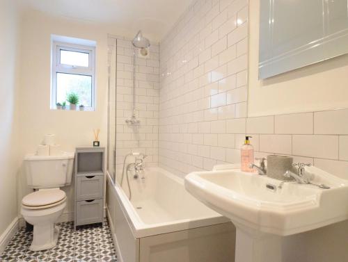 uma casa de banho com uma banheira, um lavatório e um WC. em Manor Road em Stratford-upon-Avon