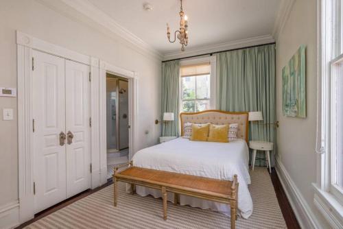 1 dormitorio con cama con banco y ventana en Waverly Suite at Mirabelle, en Savannah