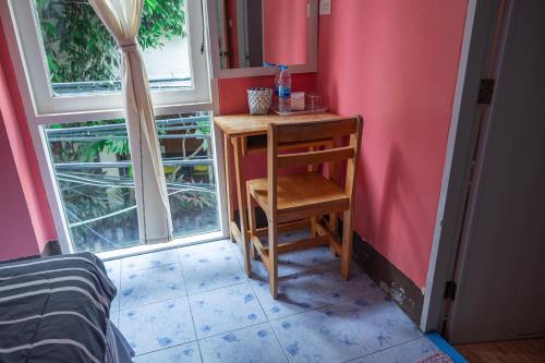 a small desk with a chair next to a window at Sea Shell Hut in Phi Phi Don
