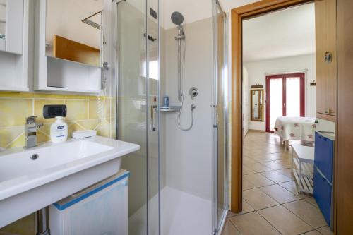 uma casa de banho com um chuveiro, um lavatório e um espelho. em L'Orso e il Mare (Adults Only) em Palau