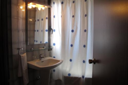a bathroom with a shower curtain and a sink at Hostal Casa Pepe in Tauste