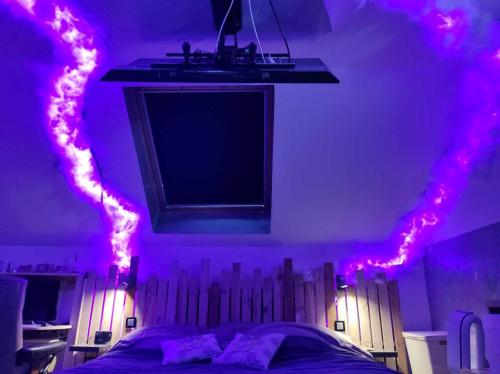 una camera con un letto con luci rosa di Maison de 2 chambres avec wifi a Dreux a Dreux