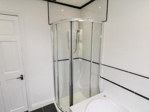 a glass shower in a bathroom with a toilet at 89 Caledonia Street in Scarborough