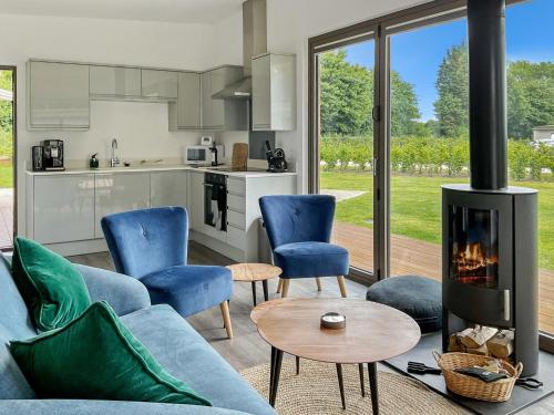 sala de estar con sofá y chimenea en Stunning "Orwell" Scandinave Lodge with Private Hot Tub, en East Bergholt