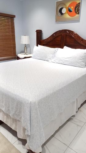 a bedroom with a bed with a white blanket on it at The Royal at Meadowbrook 3 bed rooms house in Kingston