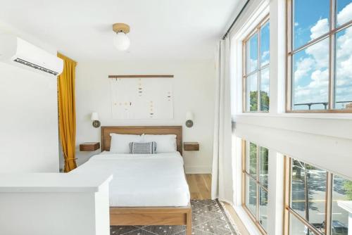 1 dormitorio con 2 camas y ventanas grandes en 2BR Loft with Terrace en Savannah