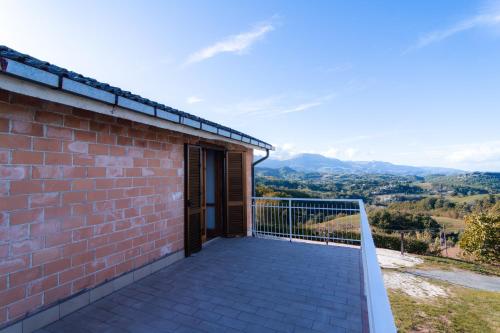 a brick house with a balcony with a view at [vista Sibillini] Villa Amici in Verri