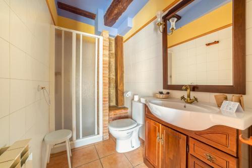 a bathroom with a toilet and a sink and a mirror at Fonda la Plaza in Valderrobres