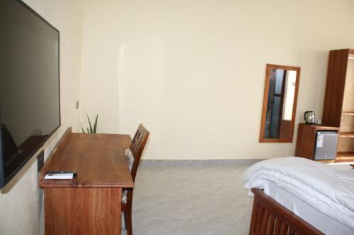 Schlafzimmer mit einem Schreibtisch, einem Bett und einem Schreibtisch in der Unterkunft Verified Lodge in Dodoma