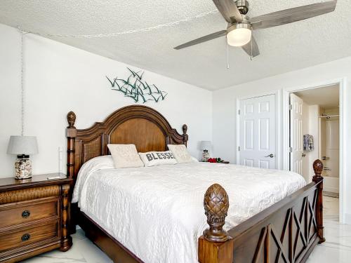 a bedroom with a wooden bed and a ceiling fan at Welcome To The Paradise in Fort Myers Beach