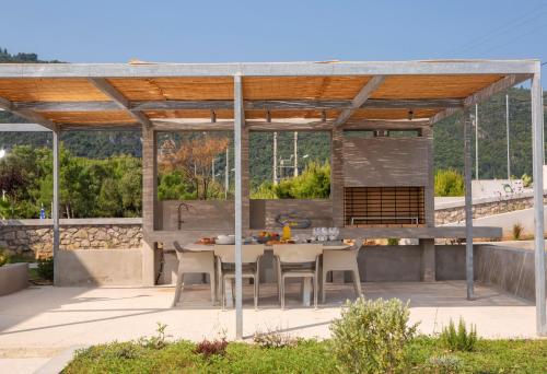 a pavilion with a table and chairs on a patio at Thines villas in Lefkada Town