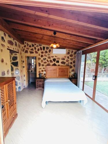 a bedroom with a white bed in a stone room at Casa Romantica in Los Palmitos