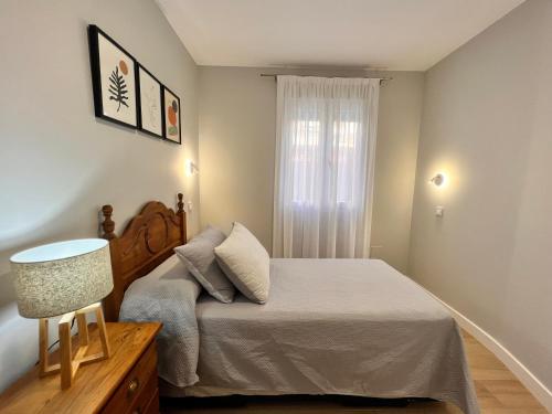 Habitación pequeña con cama y ventana en Apartamento reformado centro de Santander, en Santander