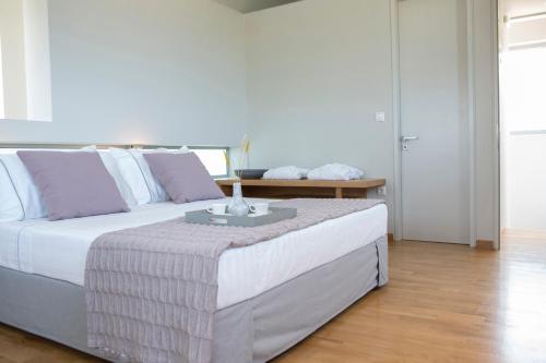 a bedroom with a large bed with a table on it at Thines villas in Lefkada Town