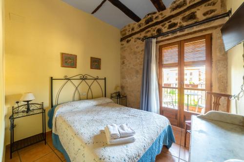 a bedroom with a bed with towels on it at Fonda la Plaza in Valderrobres