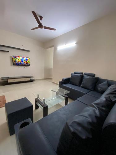 a living room with a couch and a ceiling fan at Bigson Service Apartments, Kondapur in Hyderabad