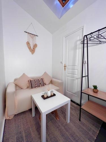 a living room with a couch and a table at Studio proche Stade de France in Saint-Denis