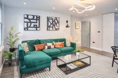 a living room with a green couch and a table at Be London - The Chinatown Residences in London