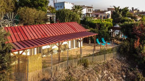 una casa con techo rojo y valla en Sunset Retreat Cyprus, en Pendakomo
