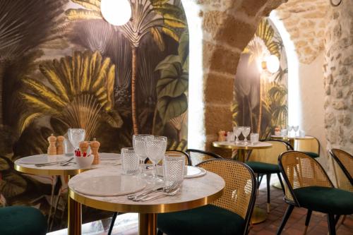 ein Restaurant mit Tischen und Stühlen und einem Wandbild in der Unterkunft Hôtel De Fleurie in Paris