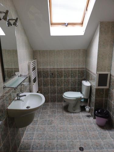 a bathroom with a sink and a toilet and a skylight at Guest Rooms DEVA in Burgas