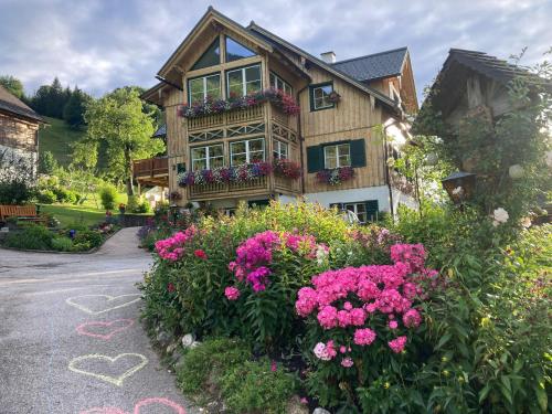 a house with flowers on the side of a road at S'Rastl direkt mit Bergpanorama in Grundlsee