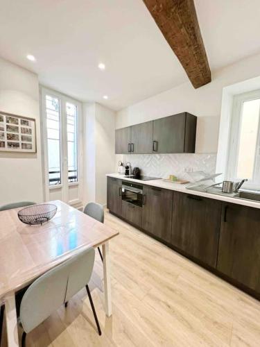 une cuisine avec une table et une salle à manger dans l'établissement Le James Close: Apt 4 Prs standing - Vieille Ville, à Antibes