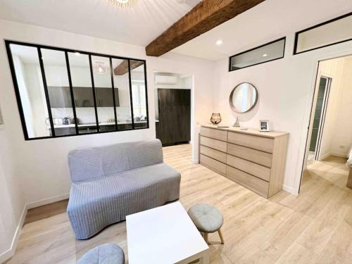 un salon avec une chaise et un miroir dans l'établissement Le James Close: Apt 4 Prs standing - Vieille Ville, à Antibes