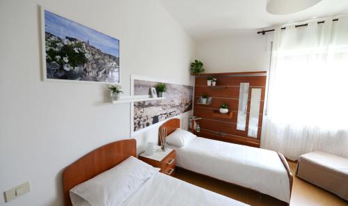 マテーラにあるLA CASA DEL FORNAIOのベッド2台とソファが備わる小さな客室です。