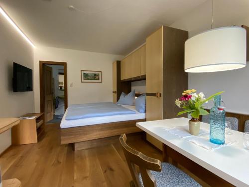 a bedroom with a bed and a table with flowers on it at Oberleiten Apartments in Wagrain