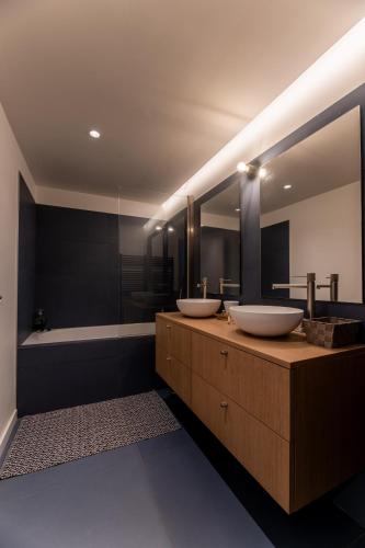 une salle de bain avec deux lavabos et une baignoire dans l'établissement Appartement cosy, vue mer, terrasse et parking situé à Beaurivage, à Biarritz