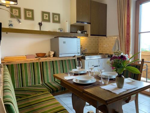 a kitchen with a wooden table with wine glasses at Oberleiten Apartments in Wagrain
