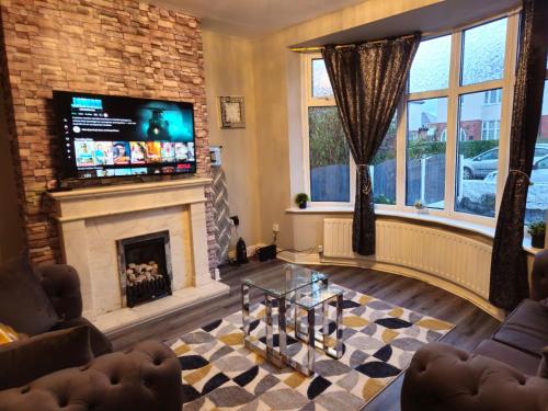 a living room with a fireplace and a flat screen tv at Clifton House, For Holidays, Contractors, Relocation, Work, Etc, Free Parking and Wifi in Preston