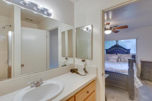 baño con lavabo, espejo y cama en Convenient Bakersfield Townhome with Patio!, en Bakersfield