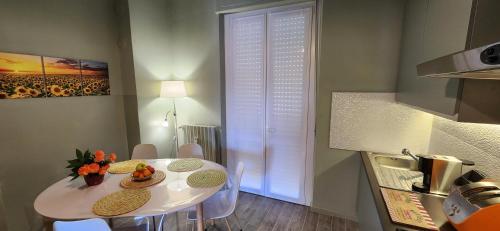 a small white table in a kitchen with a table and chairs at Sunshine House in Alessandria