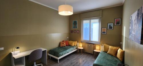 a room with two beds and a desk and a window at Sunshine House in Alessandria