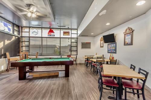 a pool table in a restaurant with tables and chairs at Suburban Studios Salt Lake City Airport in Salt Lake City