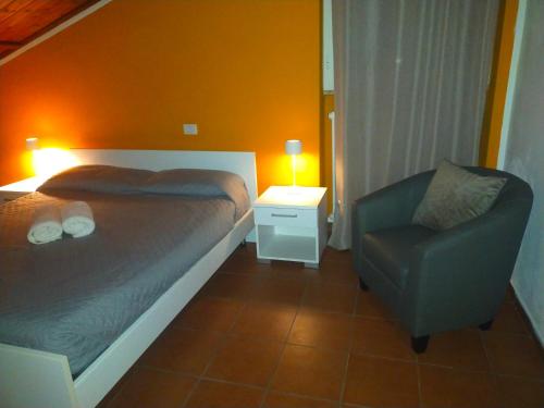 a small bedroom with a bed and a chair at Loft Belvedere in Sulmona