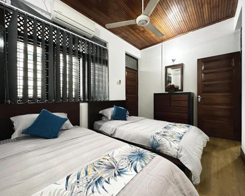 dwa łóżka siedzące obok siebie w sypialni w obiekcie Aadaraya Colombo 7 w Kolombo