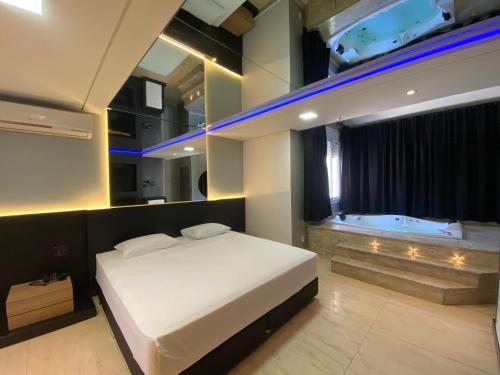 a bedroom with a bed and a tub in it at Drops Motel Porto Alegre in Porto Alegre