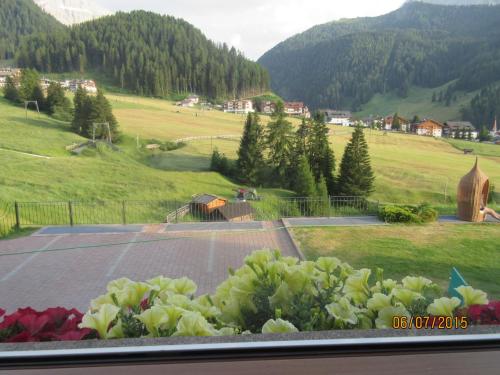 a view from a window of a field with flowers at Garni La Majon in Selva di Val Gardena