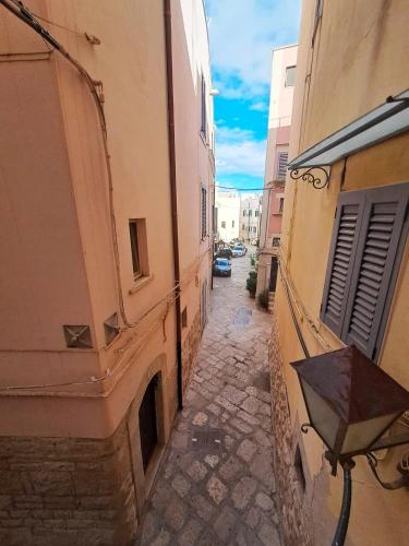 an alley with a building and an umbrella on it at Maison Divino in Trani