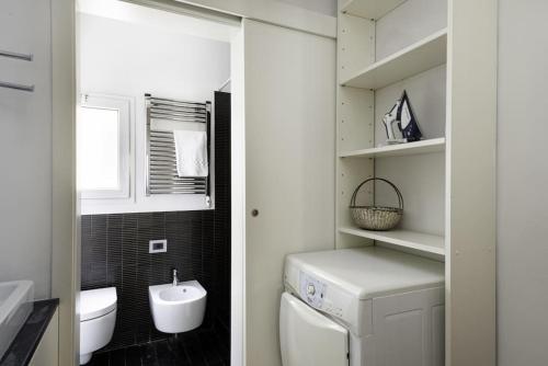 a bathroom with a sink and a washer and dryer at UNYCA - Residenza San Lorenzo in Florence