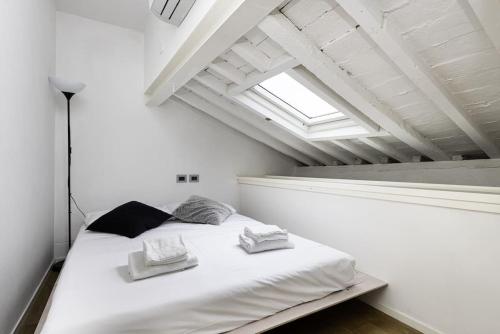 a white bed in a white room with a window at UNYCA - Residenza San Lorenzo in Florence