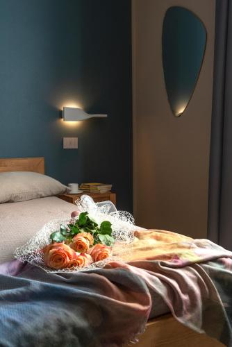 a bouquet of roses on top of a bed at d'Ocalée Holiday Experience lago d'Orta in Omegna